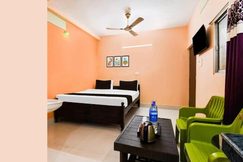a bedroom with a bed and a table and chairs at Hotel O Dakshin Dwar Formerly Radha Krishna Niwas in Puri