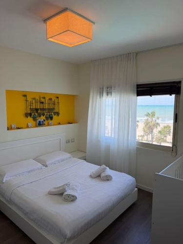 a bedroom with a bed with a view of the beach at ApartHotel by Comfort Suites in Golem