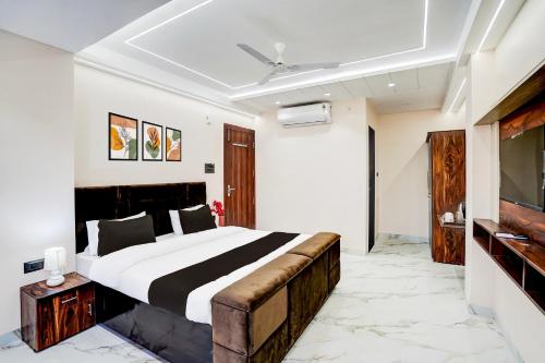 a bedroom with a large bed and a flat screen tv at Super Collection O Ganeshpuri Indore in Indore