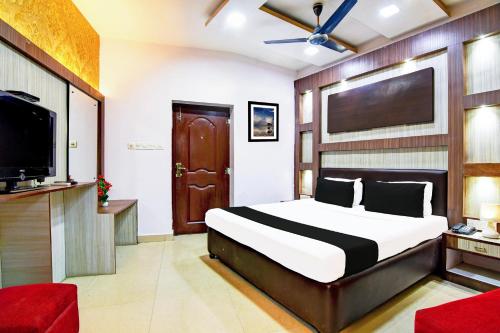 a bedroom with a bed and a flat screen tv at Collection O Karaya Road Formerly Hotel New Diamond in Kolkata