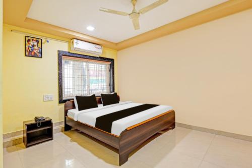 a bedroom with a bed in a room with a window at OYO Collection O NAD Near Airport in Visakhapatnam