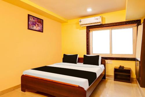 a bedroom with a bed in a room with a window at OYO Collection O NAD Near Airport in Visakhapatnam