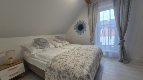 a bedroom with a bed and a window at Apartamenty Bujowy in Ustroń