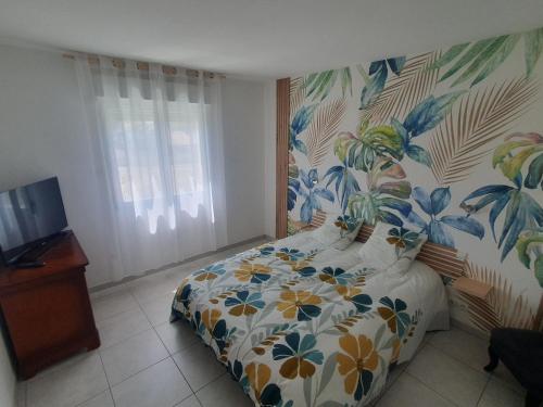 a bedroom with a bed with a floral wallpaper at Chez DavSon in Cers