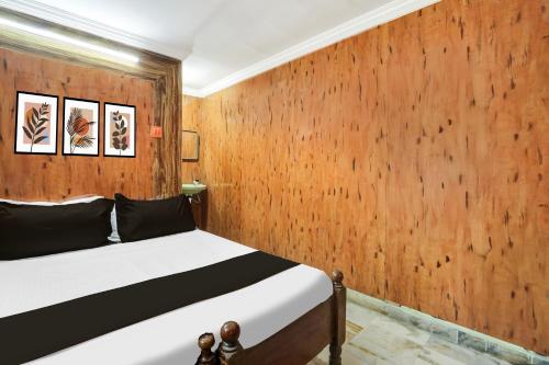 a bedroom with a bed with a wooden wall at Super Hotel O Chowrasta Near Congress Bhavan in Warangal