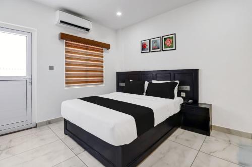 a bedroom with a black and white bed and a window at Collection O Munnar in Munnar