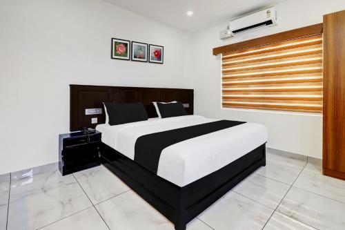 a bedroom with a black and white bed and a window at Collection O Munnar in Munnar