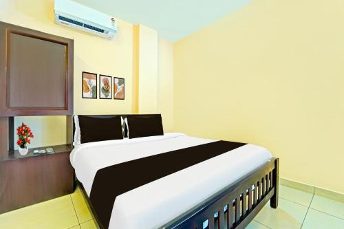 a bedroom with a large bed in a room at Super Collection O Kureepuzha Kollam in Kollam