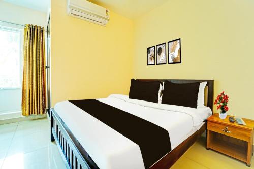 a bedroom with a large bed in a room at Super Collection O Kureepuzha Kollam in Kollam