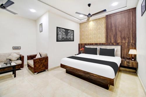 a bedroom with a bed and a desk and a chair at Super Hotel O Vijayawada Near Railway Station in Vijayawāda