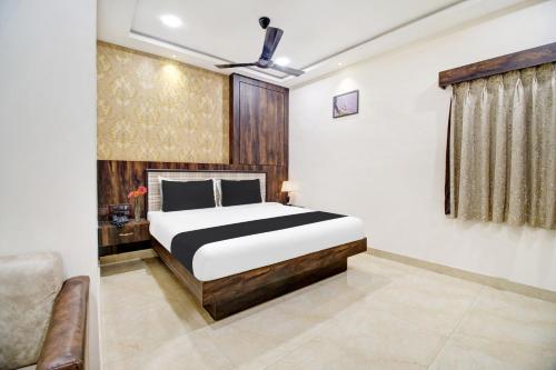 a bedroom with a bed and a couch at Super Hotel O Vijayawada Near Railway Station in Vijayawāda