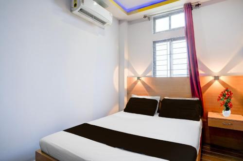 a bedroom with a white bed and a window at Hotel O Garchuk Market Formerly Trendz Stay in Guwahati
