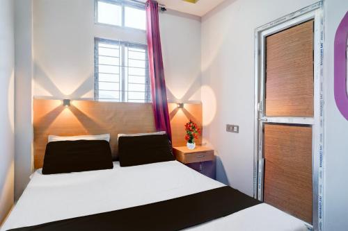a bedroom with a white bed and a window at Hotel O Garchuk Market Formerly Trendz Stay in Guwahati