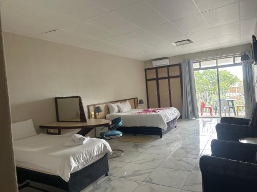 a hotel room with two beds and a couch at Caponero accommodation conference in Welkom