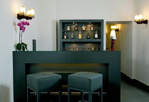 a bar with two stools next to a fireplace at Albergo Palazzo Decumani in Naples