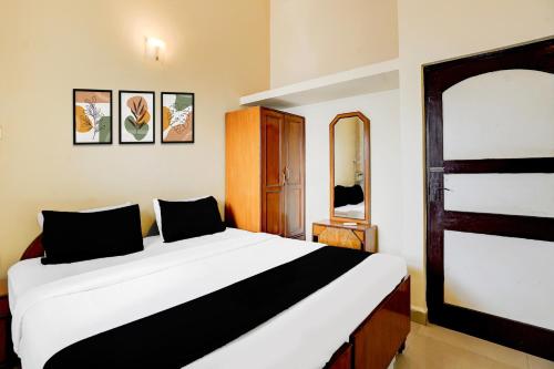 a bedroom with a large white bed in a room at Super Townhouse Calangute Formerly Hotel Horizon in Goa