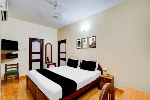 a bedroom with a bed and a chair at Super Townhouse Calangute Formerly Hotel Horizon in Goa