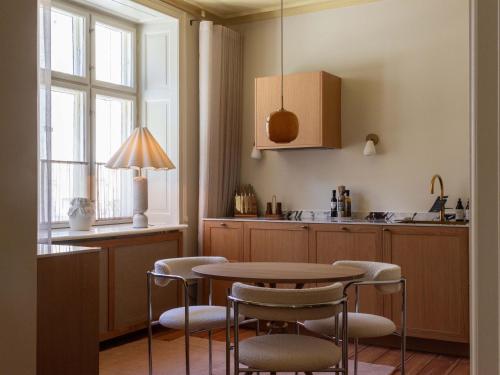 a kitchen with a table and chairs and a sink at Four Suites Copenhagen - Boutique Suites in Copenhagen