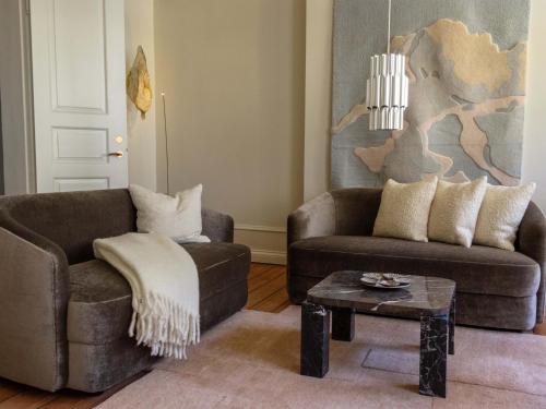 a living room with two couches and a coffee table at Four Suites Copenhagen - Boutique Suites in Copenhagen
