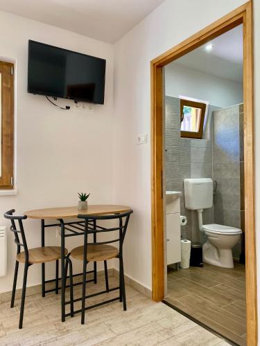 a bathroom with a table and chairs and a toilet at Tündi Vendégház in Balatonlelle