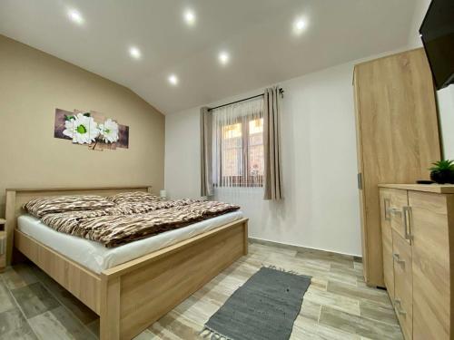a bedroom with a bed and a window at Tündi Vendégház in Balatonlelle
