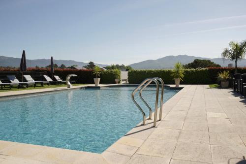 a swimming pool with a metal ladder in the middle at Casa d'Amares in Amares
