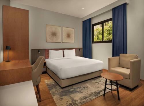 a bedroom with a bed and a desk and a chair at Hotel Sky Nest Suites Near IGI Airport Delhi in New Delhi