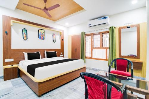 a bedroom with a bed and a red chair at OYO Hotel O Gurudwara Near RTC Complex in Visakhapatnam