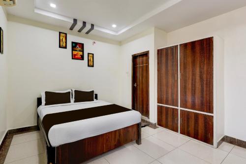 a bedroom with a bed and a large window at OYO Hotel O Benz Circle Vijayawada in Vijayawāda