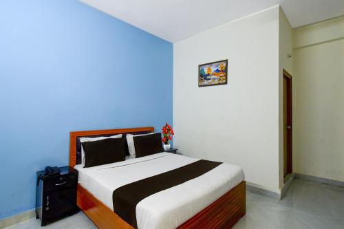 a bedroom with a large bed with a blue wall at Super Collection O Forum Mall Hyderabad Formerly Ruby Grand Inn in Kondapur