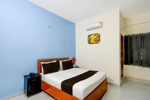 a bedroom with a bed in a blue and white room at Super Collection O Forum Mall Hyderabad Formerly Ruby Grand Inn in Kondapur