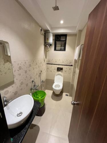 a small bathroom with a toilet and a sink at Hotel Ashoka Resort in Ellora