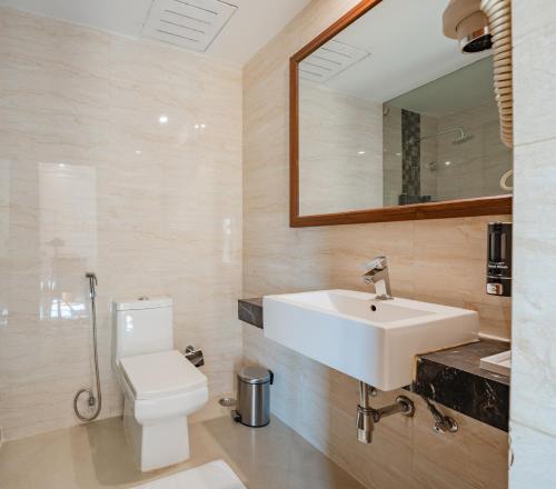 a bathroom with a sink and a toilet and a mirror at The India Benares in Varanasi