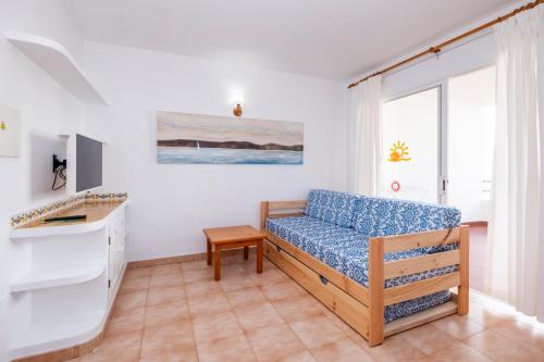 a living room with a couch and a window at Apartamentos Sol Ponent in Cala Blanca
