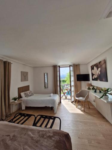 a hotel room with two beds and a balcony at Hotel Colegiata in Santillana del Mar