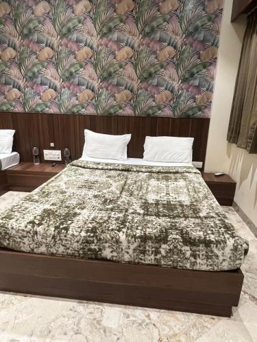a bedroom with a bed with a floral wallpaper at Hotel Ashoka Resort in Ellora