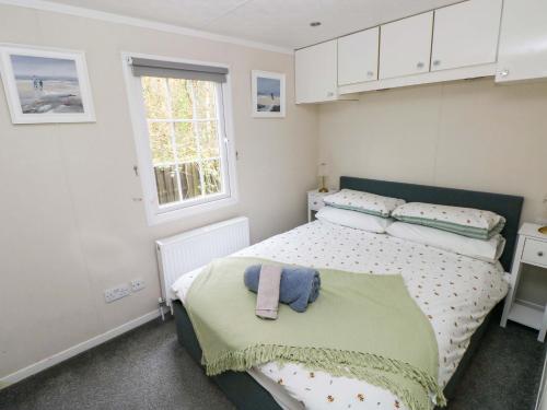a small bedroom with a bed and a window at Meadows Farm Lodge in Swansea