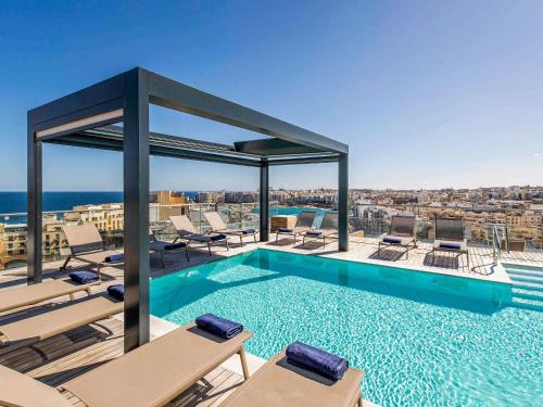 a swimming pool on the roof of a building at Mercure St. Julian's Malta in St. Julianʼs