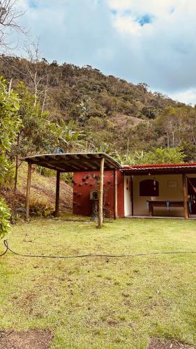 a house with a picnic table in front of it at Chácara nosso pedacinho do céu in Domingos Martins