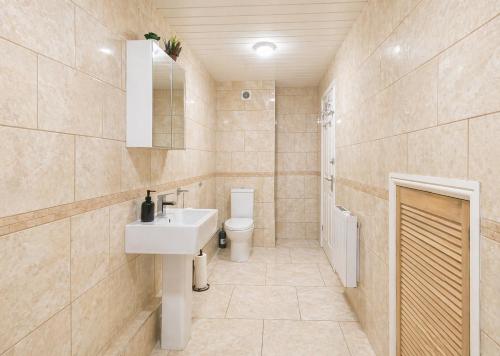 a bathroom with a sink and a toilet at Spacious, Modern and stylish three bedroom home , perfect for work , leisure and contractors ,5 mins walk to Newcastle city Center, Newcastle stadium and Newcastle University, Free parking Fast WiFi, conveniently located both short stay and long stays in Newcastle upon Tyne