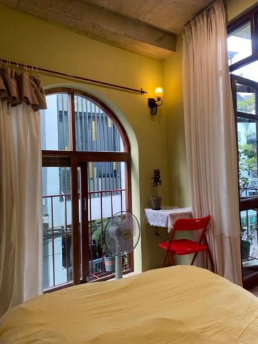a bedroom with a bed and a large window at Tiny bright house Autum space in Danang