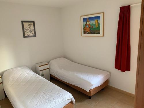 a bedroom with two beds and a picture on the wall at Villa les Mazes in Vallon-Pont-dʼArc