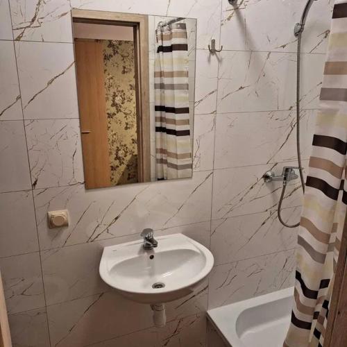 a white bathroom with a sink and a mirror at Hostel Włocławek in Włocławek