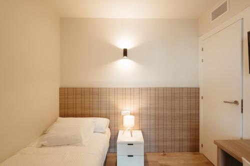 a bedroom with two beds and a light on the wall at Be1960 tercer in Bagá