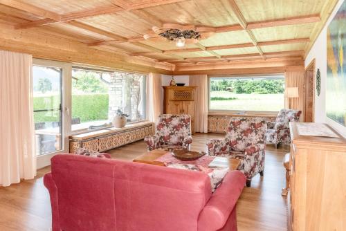 a living room with a red couch and chairs at Fischerhaus am Moosbach mit Sauna in Mietenkam