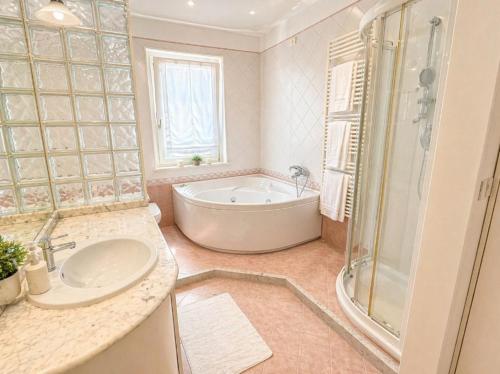 a bathroom with a tub and a sink and a shower at La Casa Gialla in Caorle