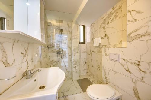 a white bathroom with a sink and a toilet at Beach Apartments in Ulcinj