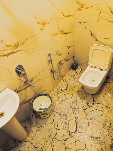 a dirty bathroom with a sink and a toilet at Gita Raman Palace in Ayodhya