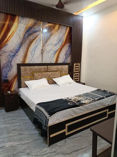 a bedroom with a large bed with a painting on the wall at Gita Raman Palace in Ayodhya