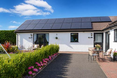 a house with solar panels on the roof at Lytton Tree Lodge Near Southwold in Reydon